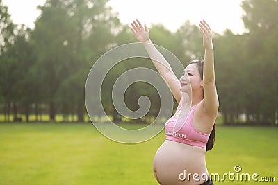 Asian Eastern Chinese happy beautiful pregnant woman hug embrace nature in green forest outdoor sunshine sunset sunrise day hope Stock Photo