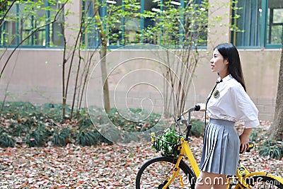 Relax Asian Chinese pretty girls wear student suit in school enjoy free time ride bike in nature spring garden Stock Photo