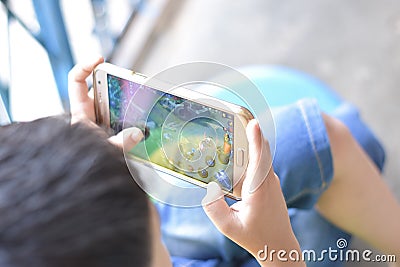 Asian Chinese little boy playing Mobile Legends game. Using smart phone. Editorial Stock Photo
