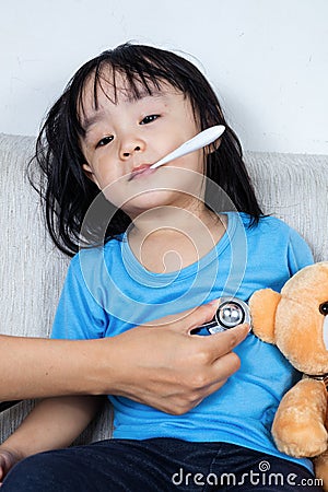 Asian Chinese little girl examine by doctor with stethoscope Stock Photo