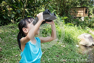 Asian Chinese little girl exploring around with binoculars Stock Photo