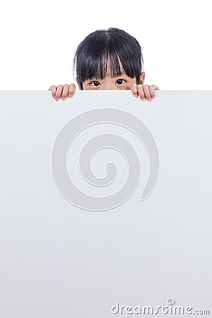 Asian Chinese little girl peeping behind white board Stock Photo