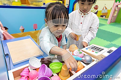 Asian Chinese little girls role-playing at ice cream store Stock Photo