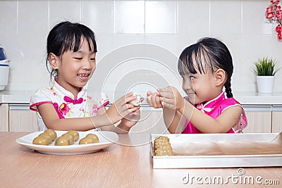 Asian Chinese little sisters making moon cake in the kitchen Stock Photo