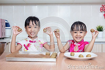 Asian Chinese little sisters making moon cake in the kitchen Stock Photo