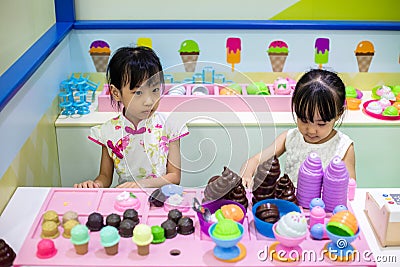 Asian Chinese little sisters role-playing at ice cream store Stock Photo