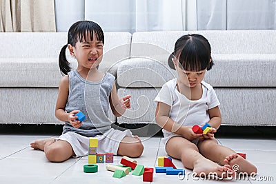 Asian Chinese little sisters struggle for blocks Stock Photo