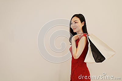 Asian Chinese modern fashionable woman girl shopping card and bag on hand in a mall white isolated background Stock Photo