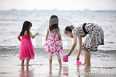 Asian Chinese mum and daughters playing sand together Stock Photo