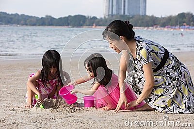 Asian Chinese mum and daughters playing sand together Stock Photo