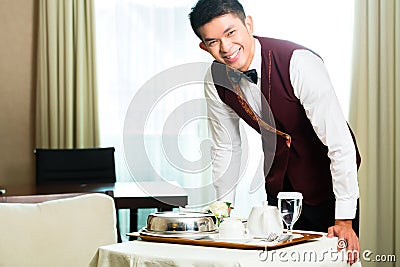 Asian Chinese room service waiter serving food in hotel Stock Photo