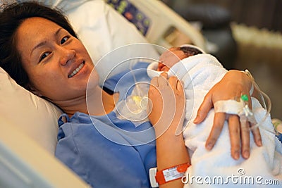 Realistic Asian Chinese woman holding her new born baby right after childbirth Stock Photo