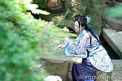 Asian Chinese woman in traditional Blue and white Hanfu dress, play in a famous garden Stock Photo
