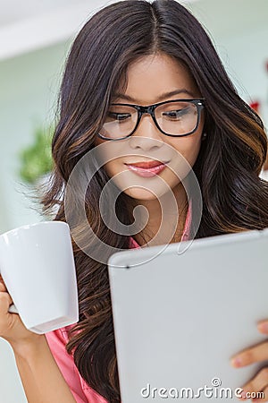 Asian Chinese Woman Using Tablet Computer Drinking Coffee or Tea Stock Photo