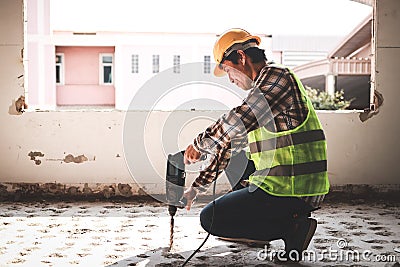 Asian construction worker using mortar extraction machine to drill concrete floor. Stock Photo