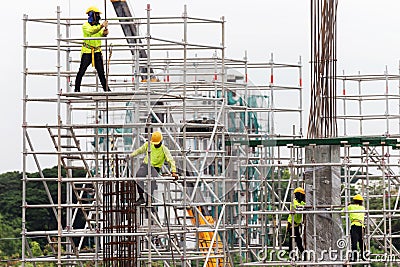 Asian construction workers working on scaffolding of building construction site in city. urban expansion in capital city of asia Editorial Stock Photo