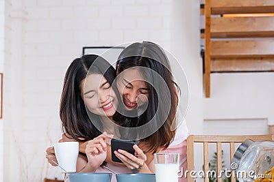 Asian couple lesbian hug each other when have breakfast in morning at home.LGBTQ lifestyle concept Stock Photo