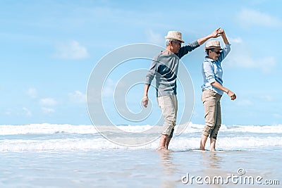 Asian couple senior elder dancing retirement resting relax at sunset beach Stock Photo