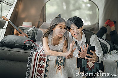 Asian couple sweet in tent inside on they camping trip Stock Photo