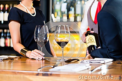 Asian couple tasting red wine in bar Stock Photo