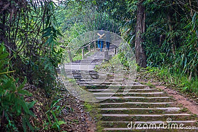 Asian couple walking on staircase up to hilltop Stock Photo