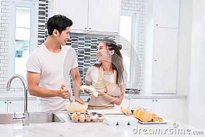 Asian couples cooking and baking cake together in kitchen room Stock Photo