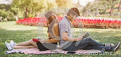 Asian couples reading a book .Campus life. Couple of students with a books. Education in nature park. Stock Photo