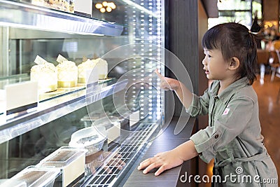 Asian cute little girl looking excited in bakery counter Stock Photo