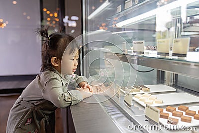 Asian cute little girl looking excited in bakery counter Stock Photo