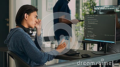 Asian database programer writing code on computer Stock Photo