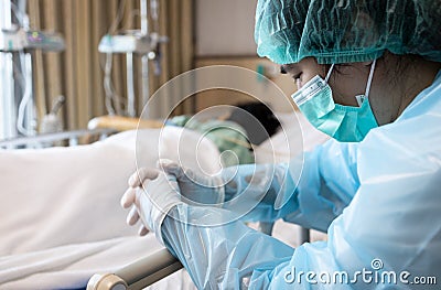 Asian daughter in face mask and medical uniform look after for sick senior mother in hospital recovery room from COVID-19 illness, Stock Photo