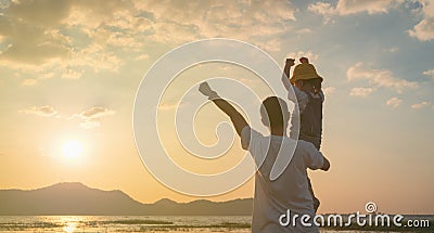 Asian daughter rode the father`s neck and looked ahead together on sunset, Dad and baby girl playing together near the lake Stock Photo