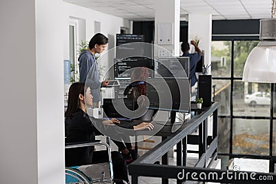 Asian disabled software programmer writing html code in agency big data room Stock Photo