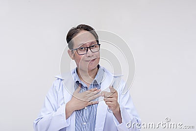 An asian doctor points to you while putting his hand on his chest as a sign of honesty, truth or reassurance. Isolated on a white Stock Photo