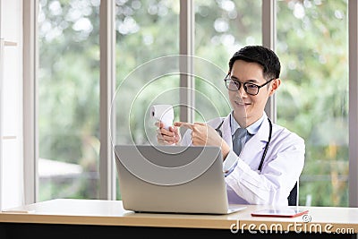 Doctor present and talking about scan head thermometer with patient or customer through online video chat with computer in Stock Photo