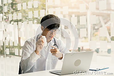 Asian doctor provides online counseling to patients during the virus outbreak keeping a social distance Stock Photo