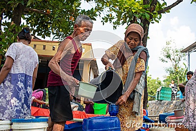 Asian elderly couple collecting relief water during the long dry season Editorial Stock Photo
