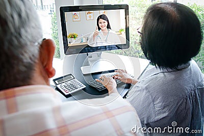 Asian elderly couples using computers Online video calling Talk to the doctor from home to inquire about health problems. Stock Photo