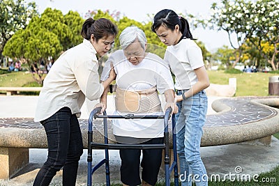 Asian elderly use walker during rehabilitation for safety after knee surgery,daughter,granddaughter help,care,support her senior Stock Photo