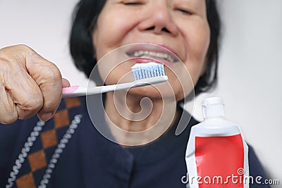 Asian elderly woman trying use toothbrush. Dental Stock Photo