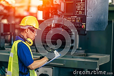 Asian engineer checking the machine in factory, worker writing note with list paper Stock Photo