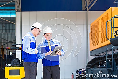 Asian engineer discussing plans on construction site Stock Photo