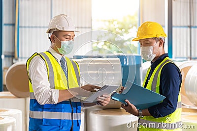 Asian engineer foreman working check list with staff worker in warehouse factory Stock Photo