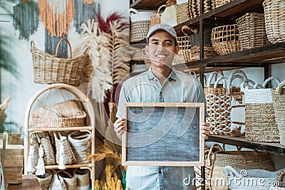 asian entrepreneur holding a blackboard standing in a handicraft shop Stock Photo