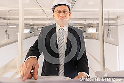 Asian executive engineer checks blueprint Stock Photo