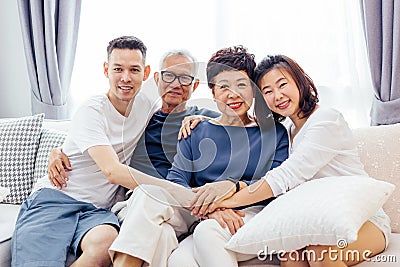 Asian family with adult children and senior parents relaxing on a sofa at home together. Stock Photo