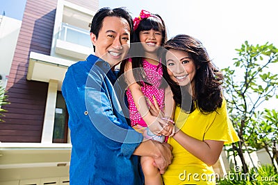 Asian family with child standing in front of home Stock Photo