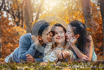 Asian family, father, mother and daugther having goodtime together in park in autumn season Stock Photo