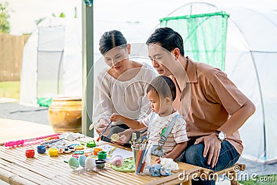 Asian family with father mother and son enjoy to have good activity together to paint eggs relate to easter festival with day Stock Photo