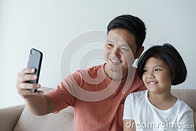 This Asian family has a father and daughter . A little girl And father video call they are happy in their home ather Stock Photo